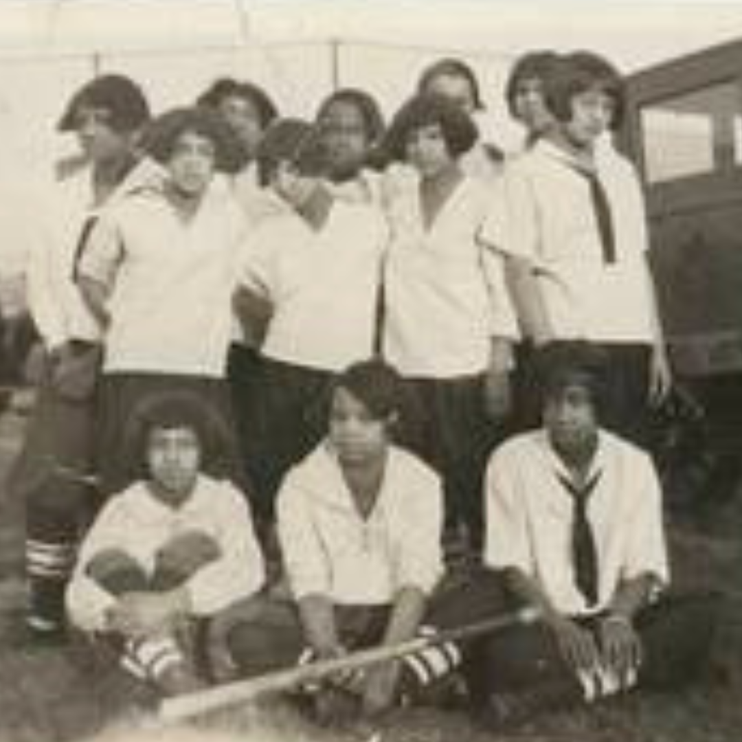 Black and white image of black girls with uniforms and a softball bat