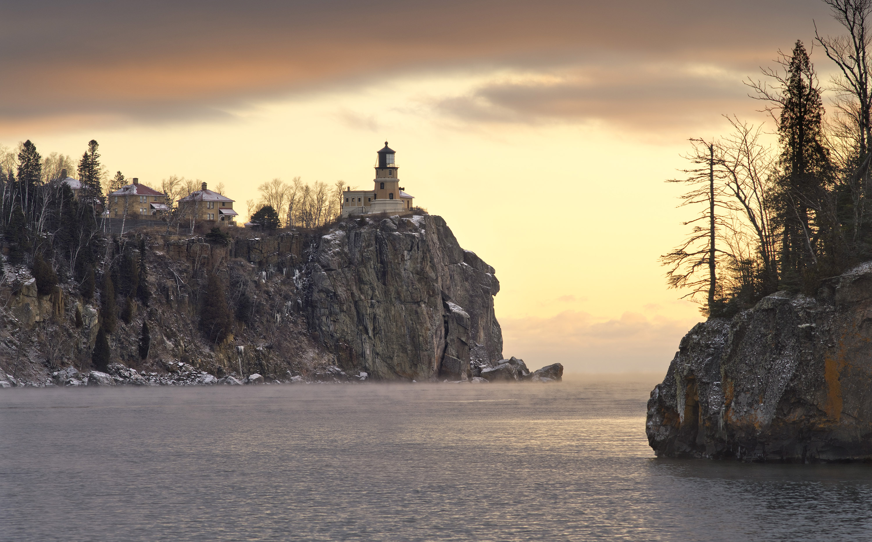 A photo taken by Ryan Tischer of Split Rock Lighthouse from a distance on a winter's evening.